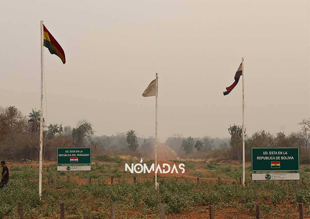 Las banderas de Bolivia y Paraguay flamean en plena frontera, donde empieza y a la vez terminan los caminos de tierra que llevan al interior de ambos países. Foto: Clovis de la Jaille/Revista Nómadas.